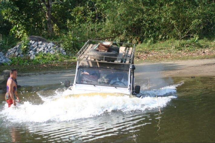 Defender franchissant un passage d’eau avec un guide