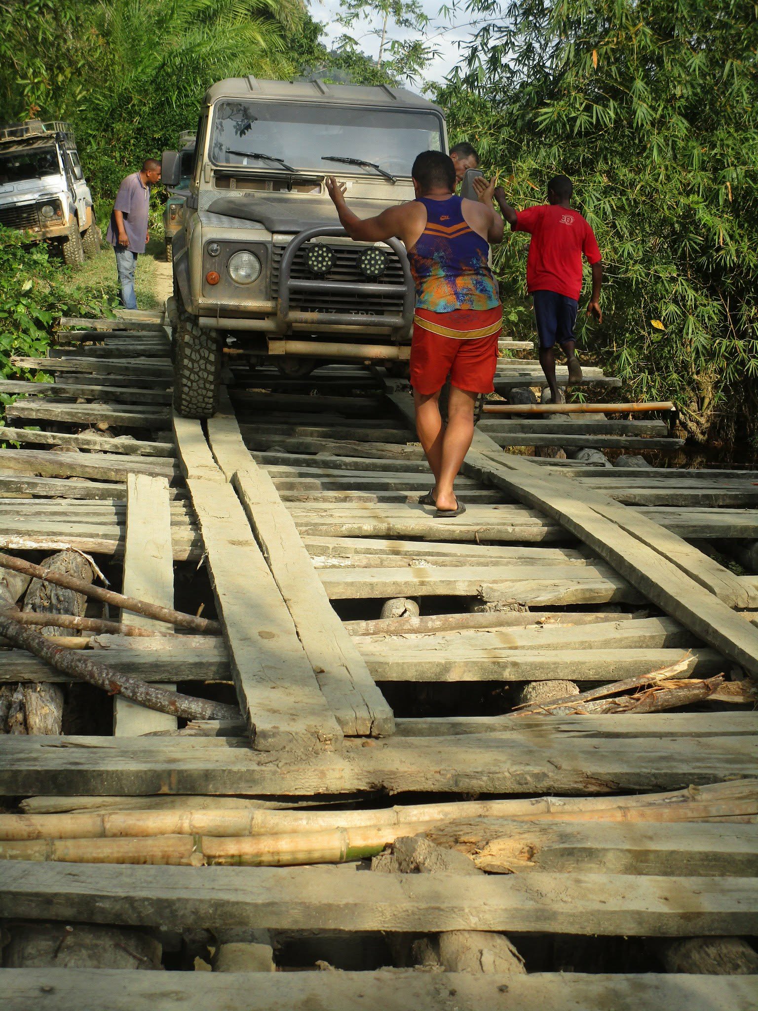 Équipe guidant un Defender sur un pont traditionnel en bois