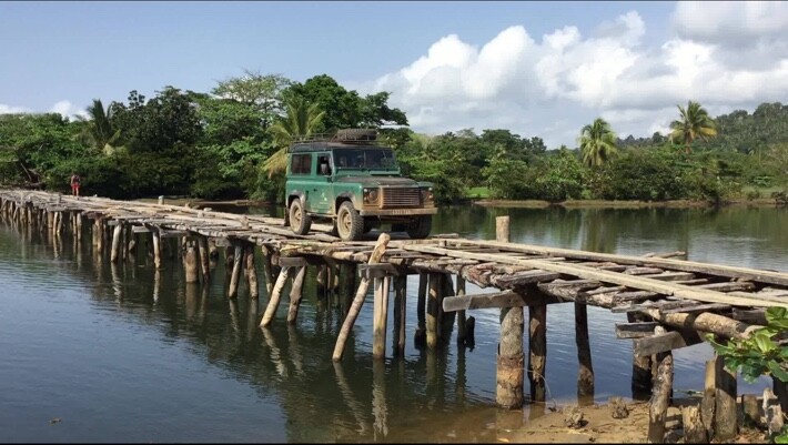 Defender vert progressant sur un pont traditionnel en bois