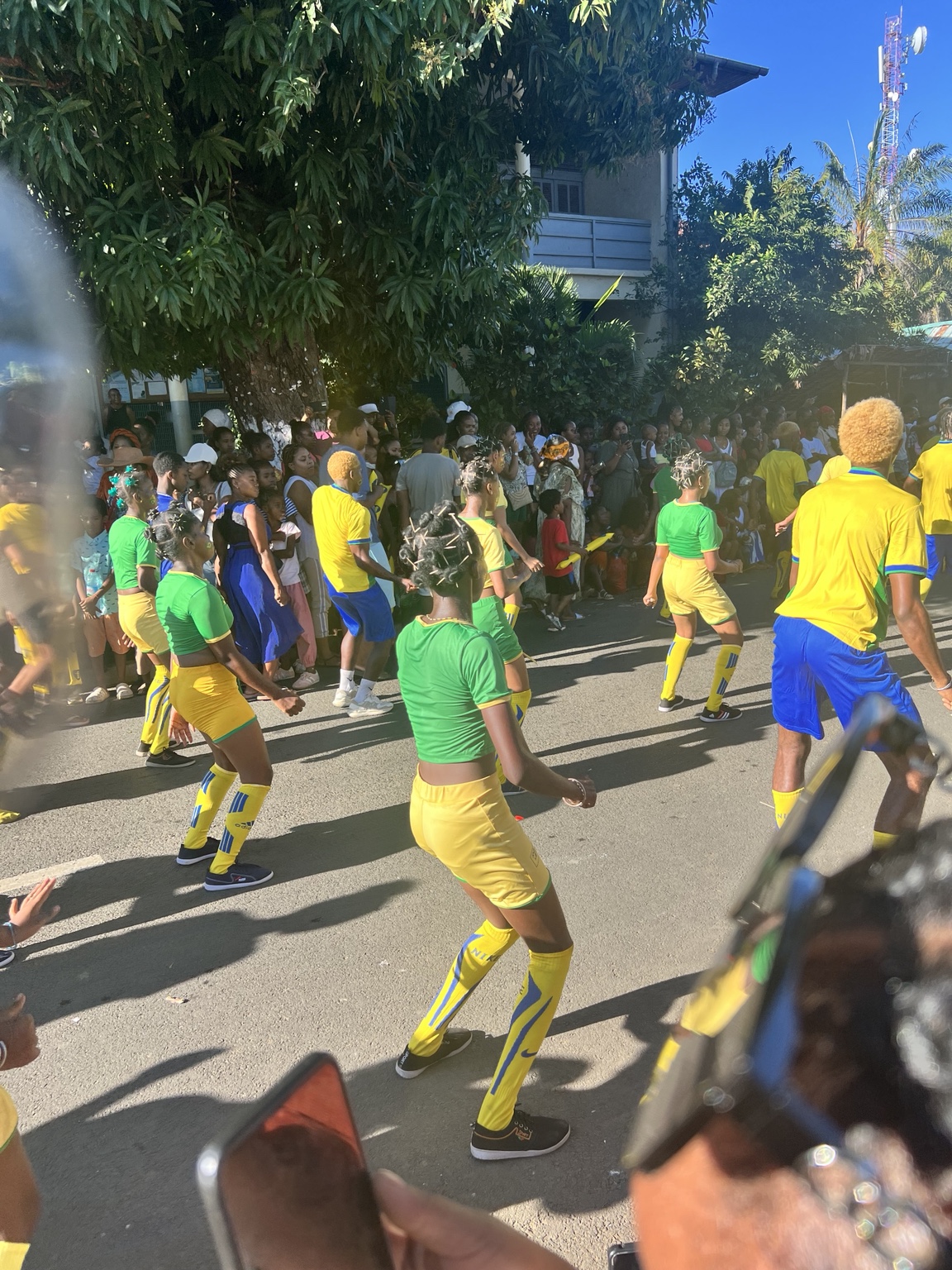 Groupe de danseurs en vert et jaune dans les rues de Hell-Ville